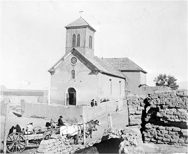 Old church with a horse drawn carriage and stone walls in front