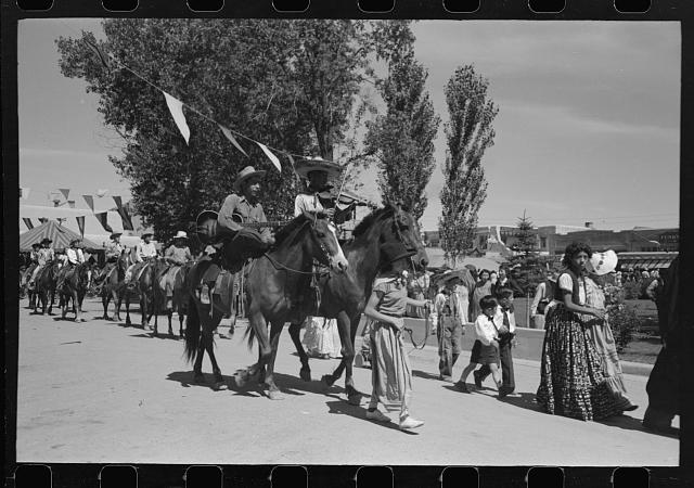 Two men riding horseback in a parade at Taos Fiestas 1940